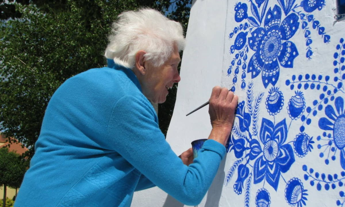 Flores azules sobre muros blancos: la historia de la mujer que convirtió su pueblo en una obra de arte